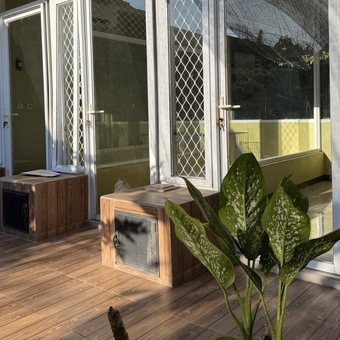 Teras kayu dengan pintu kaca menuju kamar